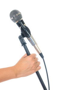 Cropped hand holding microphone against white background