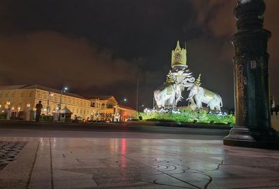 Statue at illuminated temple against sky at night