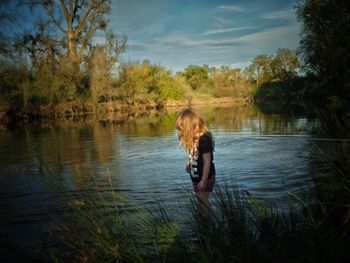 Side view of girl standing on riverbank