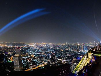 High angle view of illuminated cityscape against sky at night