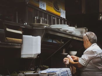 Midsection of man reading book on table