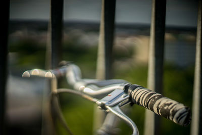 Close-up of bicycle handle by railings 