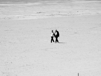 Two people walking on beach