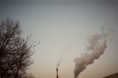 Smoke emitting from chimney against sky