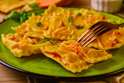 Homemade pumpkin ravioli with ricotta cheese served basil