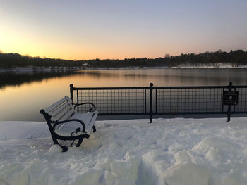 View of snow covered lake against sky during sunset