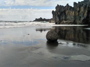 Scenic view of rocks on beach against sky