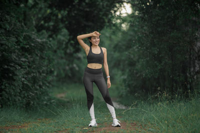 Full length portrait of young woman standing on land