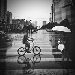 Man riding bicycle on wet street