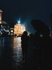 People in illuminated city at night