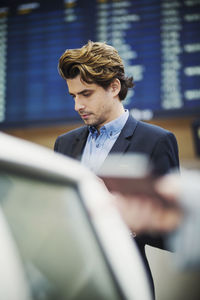 Businessman standing at airport check-in counter