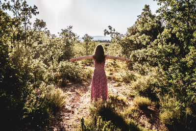 Rear view of woman standing by plants