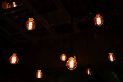 Low angle view of lit lanterns hanging on ceiling