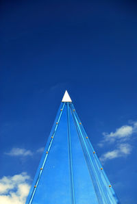 Low angle view of amusement park against blue sky