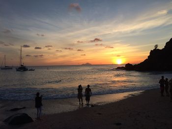 People at beach during sunset