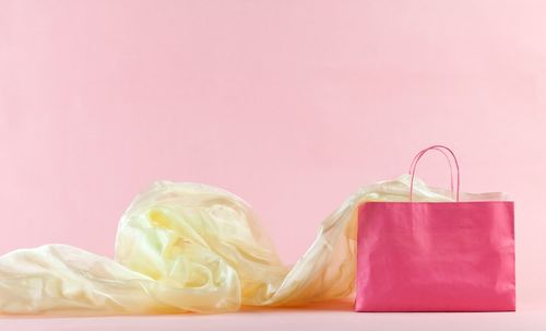 Close-up of pink paper over colored background
