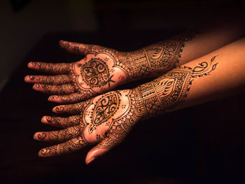 High angle view of henna tattoo on woman hands