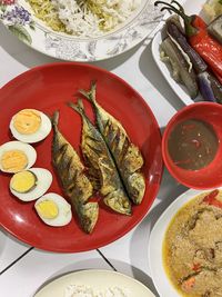 Local side dish with poached vegetables, boiled eggs, fried fish and steamed rice.