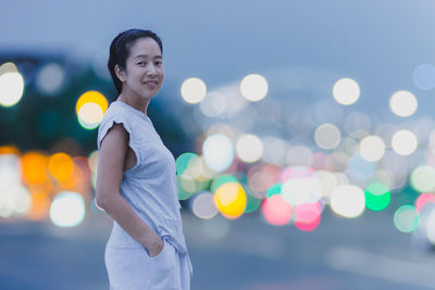 Side view of young woman exercising at night