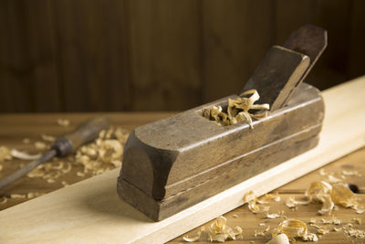 Close-up of plane on wood by shavings