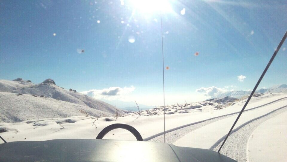 snow, transportation, winter, sun, mountain, mode of transport, cold temperature, sunlight, sky, season, landscape, beauty in nature, sunbeam, nature, mountain range, scenics, lens flare, tranquility, blue, snowcapped mountain