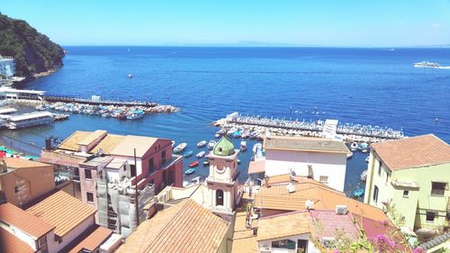 High angle view of town by sea against clear sky