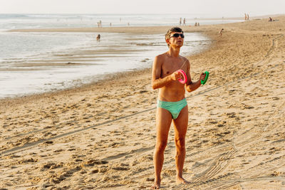 Full length of happy boy standing on beach