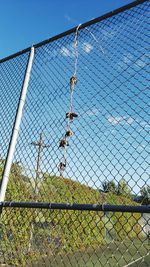 Chainlink fence on field against sky