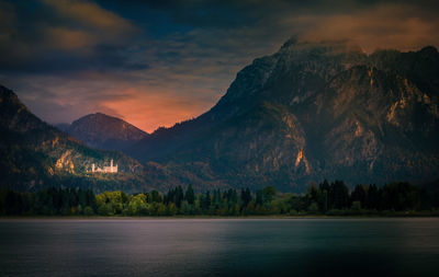 Scenic view of lake and mountains against sky during sunset