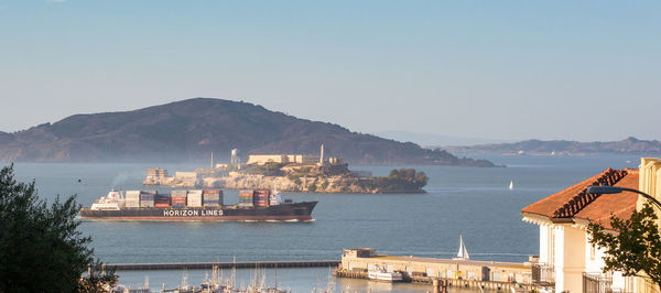 Panoramic view of sea by city buildings against sky