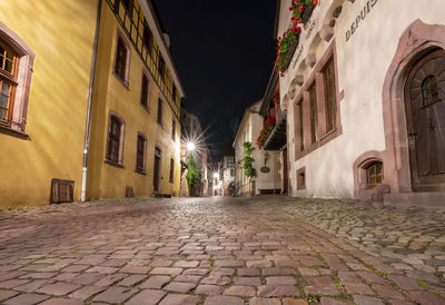 Street amidst buildings in city at night