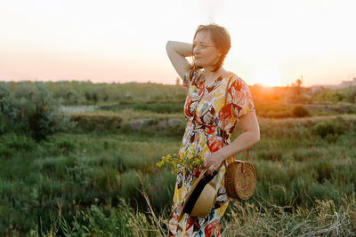 Portrait of young woman standing on field