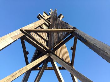 Low angle view of wooden built structure against clear blue sky