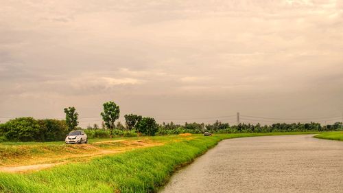 Road amidst field against sky