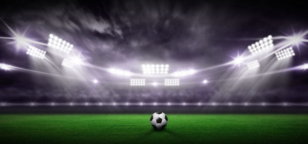 Soccer ball on land against sky at night