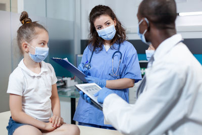 Doctors wearing mask having discussion at clinic