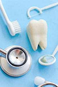 Close-up high angle view of dental equipment over blue background