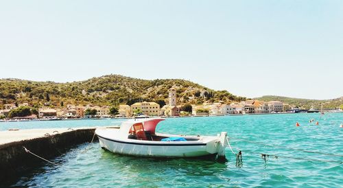 Boat moored in sea against clear sky