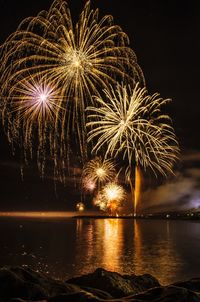 Firework display over sea at night