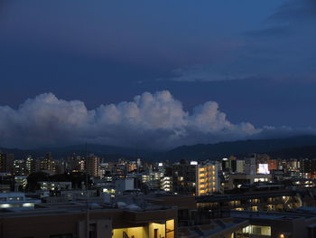 Illuminated cityscape against sky at night