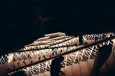 Man shadow on illuminated bridge at night