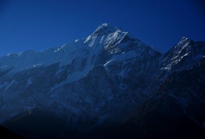 Scenic view of snowcapped mountains against clear blue sky