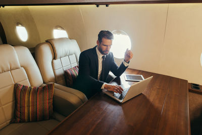 Businessman working in his private jet