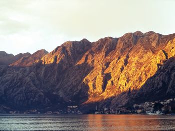 Scenic view of lake by mountains against sky