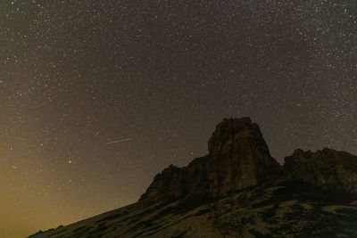 Low angle view of rock formations against sky at night