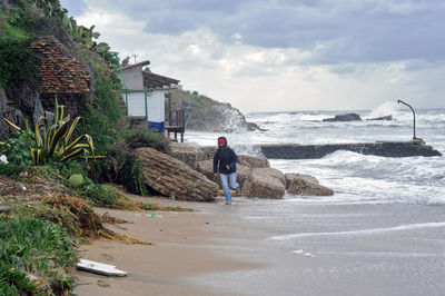 People on beach by sea against sky