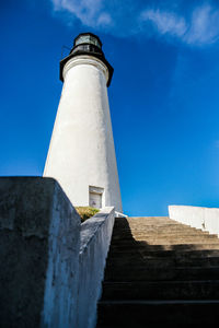 Low angle view of steps leading towards lighthouse against blue sky