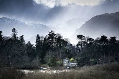 Scenic view of trees and mountains against sky