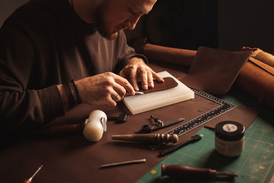 Portrait of handsome tanner man at work, small business, authentic workshop, indoors. leather goods