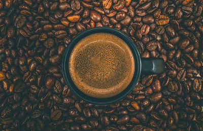 Directly above shot of coffee cup and roasted coffee beans